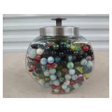 Glass jar full of assorted marbles and shooters