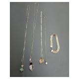 Four assorted silver necklaces, and one silver