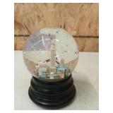 Musical snow globe with flying bats over the city