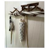 Two wall hangers, a cane, umbrellas, and grocery
