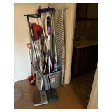 Large bin of cleaning tools; brooms, mops,