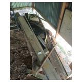 Two large scrap piles of wood, one behind shop,