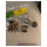 Assorted pendants and pin. One pendant is a