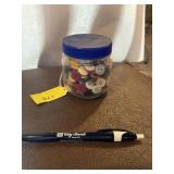 Small glass jar of vintage pastel buttons