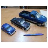 3 diecast model cars, including a blue F-150 by