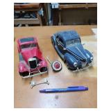 Two diecast cars, that have seen better days.