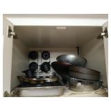 Cabinet full of assorted bakeware, cookware