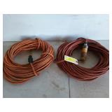 Two orange 75 ft extension cords, one has some