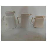 Three white / cream colored pictures, all