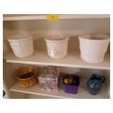Two shelves of decor, mostly flower pots, 7