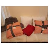 A plethora of pillows, some are new, and a red