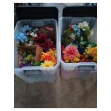 Two clear storage tubs filled with fake flowers,
