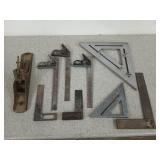An assortment of old tools, mostly squares, and