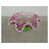 Pink frilly glass bowl with white edging, has a