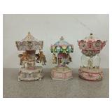 Three carousel music boxes, one is a snow globe,