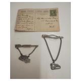 Two bulldozer tie clips, and a postcard from 1901