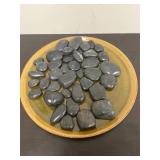 Black river stones on decorative plate