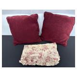 Two Burgundy Pillows and Floral Ruffled Fabric