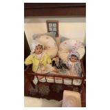 Doll bed with pillows, and four different dolls,