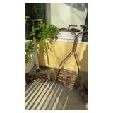 Two antique push mowers, one with a wooden handle