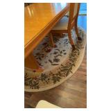 Oval carpet rug underneath the dining room table,