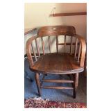antique oak captains chair featuring a rounded