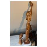 2 carved wood sculptures, one is of a woman with