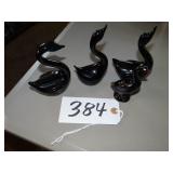 Three black glass and one ceramic swan figures