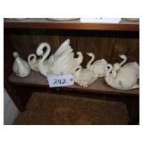 Shelf full of ceramic swan planters