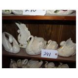 Shelf full of ceramic swan planters