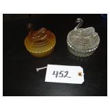 Two Jeanette glass covered swan dishes, one amber,