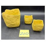 Set of yellow pottery planters, specifically re..