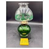 Vintage green glass oil lamp, featuring a holid..