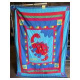 Colorful, handmade quilted blanket featuring an..