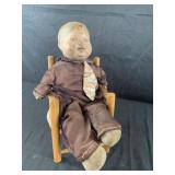 Antique boy baby doll in chairLight damage