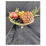 Footed glass bowl of plastic fruit