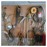 Contents of Pegboard - grease gun, saw, ripe,