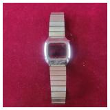 Digital watch with "W/M" emblem