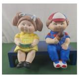 Boy and girl shelf sitters on blue bench