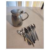 Silver colored creamer and silver colored spoons