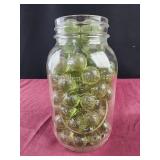Mason jar full of green glass balls