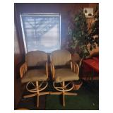 2 wooden swivel chairs and faux plant