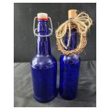 2 cobalt blue glass bottles, 1 has fairy lights