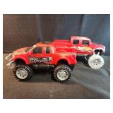 Two toy trucks, red pick up trucks, Ford raptor,
