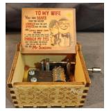 Wooden hand-crank music box that plays the tune