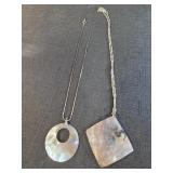 two necklaces with pendants made from iridescent