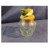 Green glass jar with decorative fruit lid