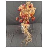 Clear vase with decorative rocks and dried roses