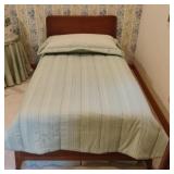 Twin size wood bed with comforter and pillow