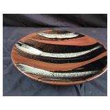 ceramic plate featuring black and orange trailed